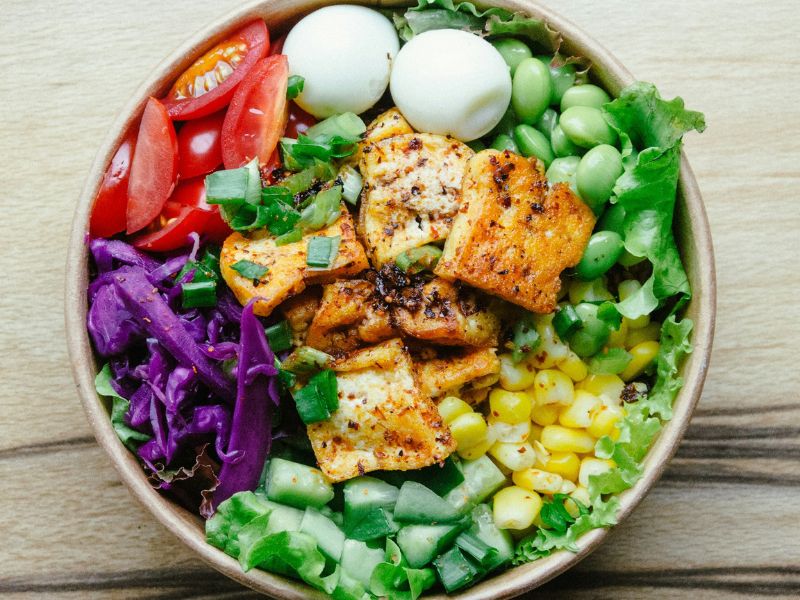 A colourful high-protein meal bowl with eggs, edamame, tomatoes and vegetables — the type of meal that supports natural GLP-1 production
